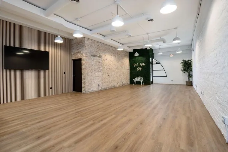 Montrose Studio main room with exposed brick, a wood slat wall and a wall-mounted TV